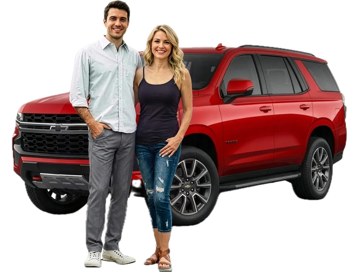 Two customers standing in front of a red SUV after securing invoice pricing on their new vehicle.